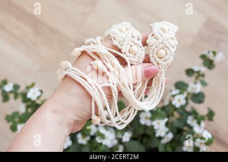Handmade macrame dress belt. Natural cotton threads and wooden beads. Stylish decoration for women 's dress.  Macrame braiding and cotton threads. Stock Photo