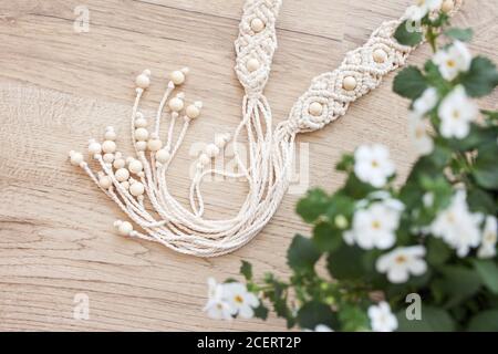 Handmade macrame dress belt. Natural cotton threads and wooden beads. Stylish decoration for women 's dress.  Macrame braiding and cotton threads. Stock Photo