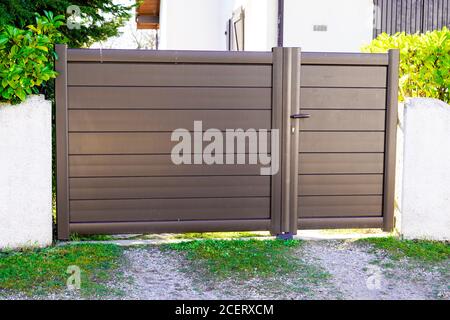 Metal brown driveway entrance gates house access garage in suburb Stock Photo