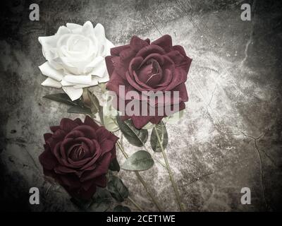 Artificial flowers: three roses on a dark background Stock Photo