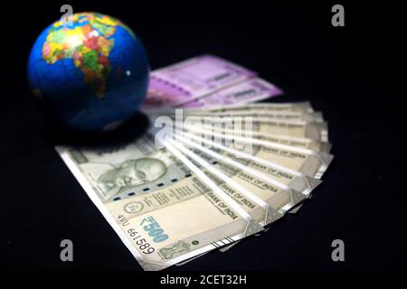 New Indian currency. 500, and 2000 rupee notes with globe. Indian currency isolated on black background. Stock Photo