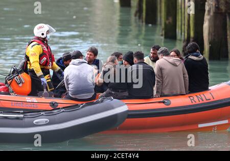 A group of people thought to be migrants are brought into Dover, Kent, by the RNLI following a small boat incident in the Channel. Stock Photo