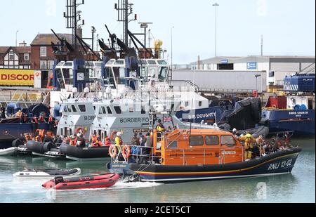 A group of people thought to be migrants are brought into Dover, Kent, by the RNLI following a small boat incident in the Channel. Stock Photo