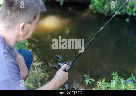 fishing wobbler in hand on a river background close-up place for