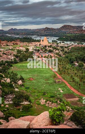 virupaksha temple with bright dramatic sky and rocky mountain background at morning image is taken at Matanga hill hampi karnataka india. it described Stock Photo