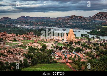 virupaksha temple with bright dramatic sky and rocky mountain background at morning from hill top image is taken at Matanga hill hampi karnataka india Stock Photo