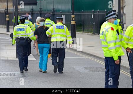 London, UK. Protester being led away after being arrested at an Extinction Rebellion protest in Parliament Square, 1st September 2020