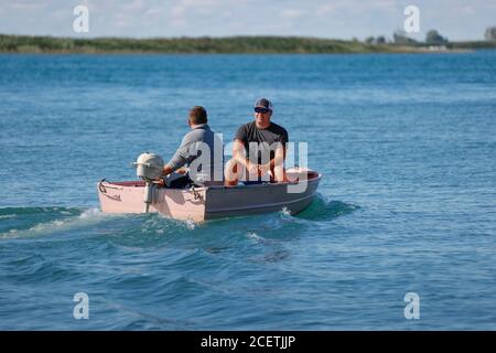 https://l450v.alamy.com/450v/2cetjjp/two-men-in-a-small-outboard-powered-boat-on-a-lake-2cetjjp.jpg
