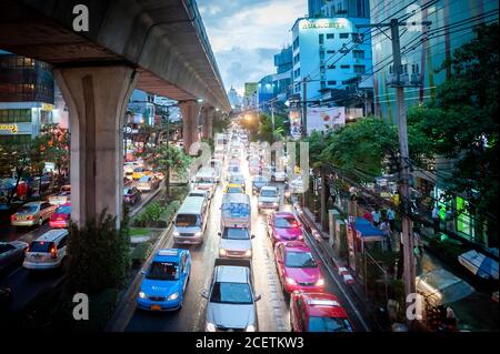 Looking down on the congested Sukhumvit Rd close to  Asoke junction at dusk. Shot from a raised walk way crossing the road. Bangkok Thailand. Stock Photo