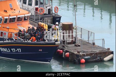 A group of people thought to be migrants are brought into Dover, Kent, by the RNLI following a small boat incident in the Channel. Stock Photo