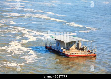 Small passenger ferry on the flowing water Stock Photo