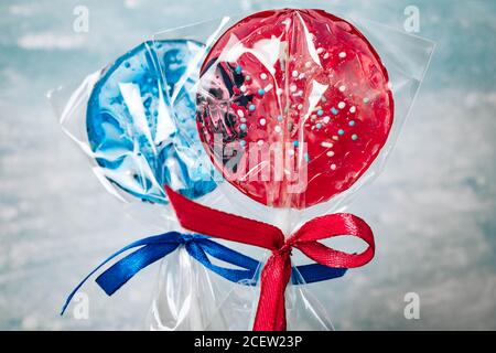 Two blue and two red lollipops isolated on blue background. Confectionery products Stock Photo