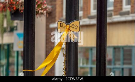 A gold ribbon is displayed in the middle of a pedestrian street to commemorate the Childhood Cancer Awareness Month. Stock Photo