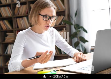 Concentrated young woman freelancer working on modern laptop Stock Photo