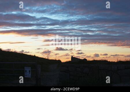 Beautiful pink and orange sunset in the countryside with pretty clouds seen from Trefor, North Wales Stock Photo