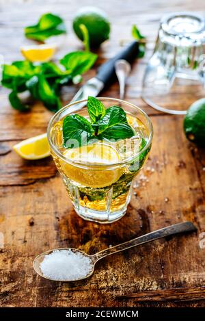 Mojito drink ingredients on vintage wooden table. Mint, sugar and lime slices for cuban shoot cocktail making from above. Fresh capirinha beverage on Stock Photo