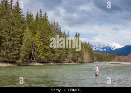 a fisherman fishing for Steelhead on a river in the Skeena Region of British Columbia Canada Stock Photo