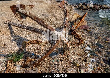 Old unused rusty anchor on the sea shore Stock Photo