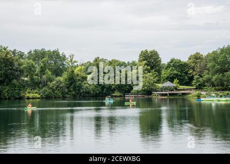 Naperville, Illinois, United States-April 24, 2014: People kayaking and paddle boating in the riverwalk quarry with greenery in Naperville, Illinois Stock Photo