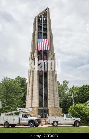Naperville, Illinois, United States-April 24, 2014: Millennium Carillon, bell tower, with American flag and trucks, in Naperville, Illinois Stock Photo