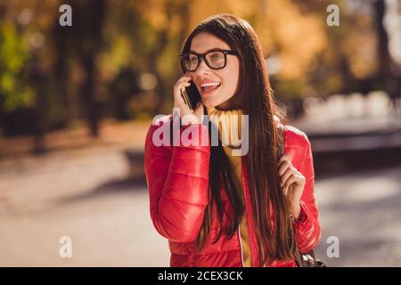 Photo of positive cheerful girl tourist enjoy travel fall park city center call friend smartphone tell say tour news wear october outerwear Stock Photo