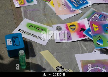 Protesters spraying erasable chalk paint onto bee and Extinction Rebellion symbol stencil design Stock Photo