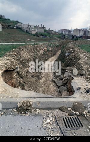 27th April 1994 During the Siege of Sarajevo: giving cover from Bosnian Serb snipers, a trench runs towards the apartment blocks of Dobrinja, skirting the hill in Mojmilo. Stock Photo