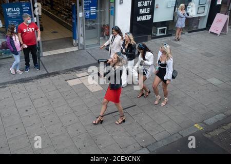 During the Coronavirus pandemic, when social distancing and partying is being discouraged, a group of hen party women walk through Waterloo, one of whom is swigging from a bottle of booze, on 29th August 2020, in London, England, Stock Photo