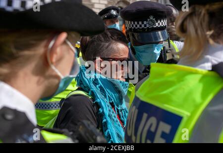 Extinction Rebellion protester gets arrested outside the Houses of Parliament by police during the 2020 demonstrations. UK Stock Photo
