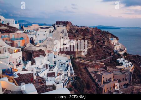 Santorini island Oia sunset landscape. Traditional white houses and castle ruins with sea view. Travel to Greece. Stock Photo