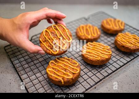 Cropped unrecognizable person hand holding biscuits with caramel sauce Stock Photo