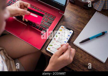 Side view of unrecognizable young female sitting in outdoor cafe and typing on keyboard of modern laptop Stock Photo