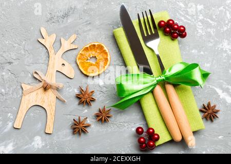 New year set of fork and knife on napkin. Top view of christmas decorations and reindeer on cement background. Close up of holiday family dinner conce Stock Photo