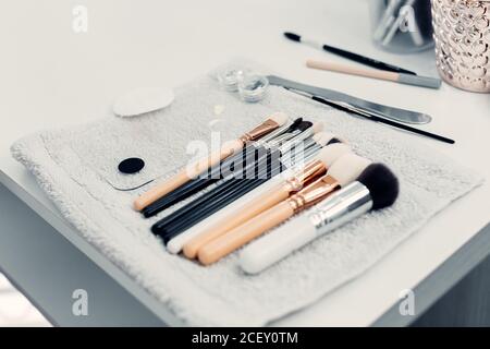 Collection of assorted brushes for makeup arranged on table in bright beauty salon Stock Photo
