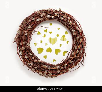 Spring Easter wreath, willow tree branches, green hearts, white background. Top view decorations flat lay spring banner Stock Photo