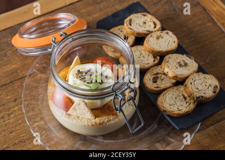 High angle of delectable chickpea hummus with truffle arranged with raisin bread on wooden table in restaurant Stock Photo