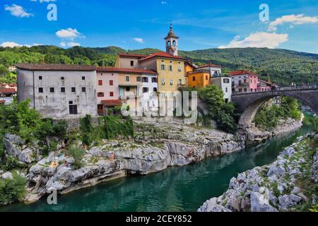 Kanal ob Soči in Slovenia. Picture of beautiful colorful buldings standing on a stone with Soča river and bridge. Stock Photo