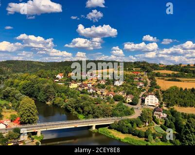 A colorful photo view of a village with some clouds on a blue sky, Sazava river and bridge taken from a Cesky Sternberk castle in Czech Republic Stock Photo