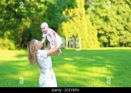 Young family with a child in the park. Portrait of mom and daughter outdoors Stock Photo