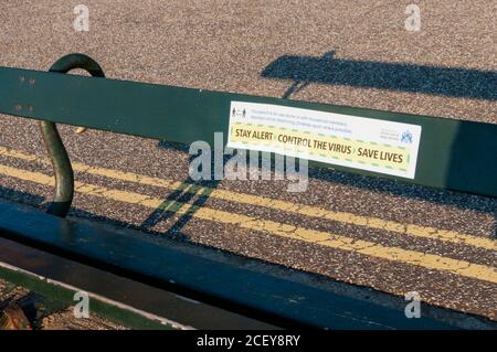 Sign on a public bench during 2020 coronavirus COVID-19 pandemic says it is for one person or members of same family. Stock Photo