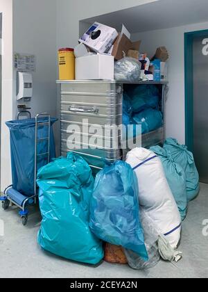 in the corner of a hospital corridor different garbage bags are piled up Stock Photo