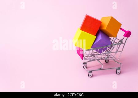 Close-Up Of Miniature Shopping with multicolor boxes inside on pink background. Shopping, purchases, supermarket, sale, mall concept Stock Photo