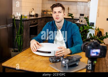 open-minded blogger show his new device at camera, man try to be interesting for subscribers, highlights new technologies in his own channel, internet Stock Photo