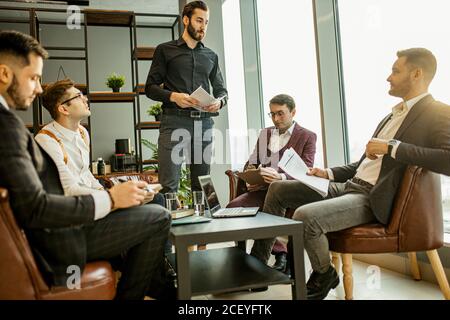young caucasian successful business men hold meeting for making useful cooperation between companies, developing business strategies together in offic Stock Photo
