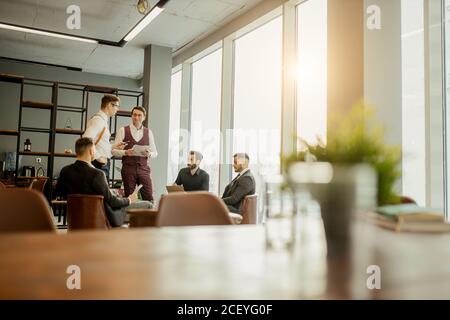 side view on business people in tuxedo discussing projects and new ideas, startups. successful men coworking in modern office Stock Photo