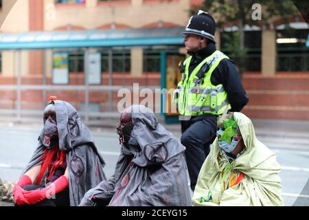 Cardiff, Wales, UK. 2nd Sep 2020. Extinction Rebellion Protestors gather at the Senedd in Cardiff highlighting the danger of rising tides and the risk of flooding in Cardiff due to climate change, 2nd September 2020. Masked protestors flanked by a police officer Credit: Denise Laura Baker/Alamy Live News Stock Photo