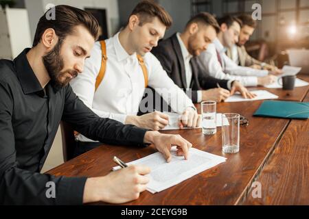 business people hold meeting in office discussing and speaking about business projects, ideas and strategies for future. successful confident men in e Stock Photo