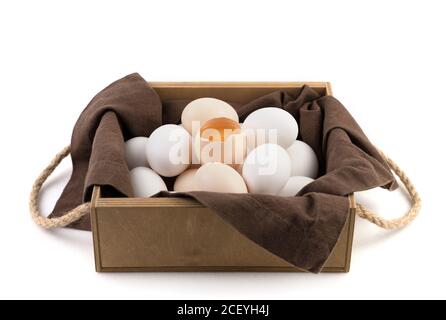 Fresh chicken eggs are white and brown with a broken egg in the center where the fresh yolk is visible. Stock Photo