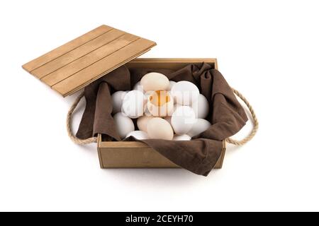 The eggs are white and brown with a broken egg in the center, in which a fresh yolk is visible. Stock Photo