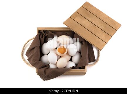 The eggs are white and brown with a broken egg in the center, in which a fresh yolk is visible. Stock Photo